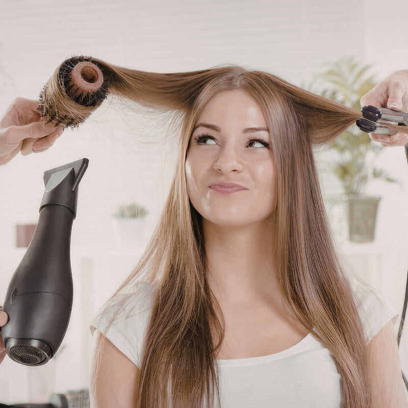 Woman getting her hair styled with a hair dryer and brush in a home setting.