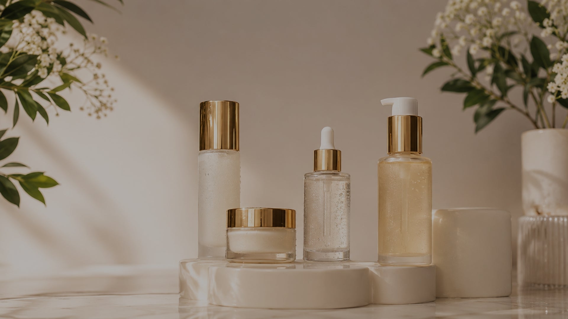 Set of skincare products on a neutral background with plants